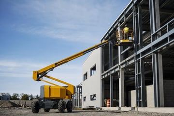 Articulating boom lift at a commercial worksite, illustrating boom lifts financing for small business: what to expect