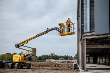 Articulating boom lift at a commercial worksite, illustrating boom lifts financing rates: what to expect
