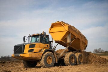 Dump trucks at a commercial worksite, illustrating dump trucks financing rates: what to expect