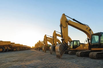 Heavy equipment on a dealer lot at a commercial worksite, illustrating equipment dealer financing program