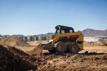 Skid steer on desert construction site at a commercial worksite, illustrating equipment financing in arizona: rates, terms and how to qualify