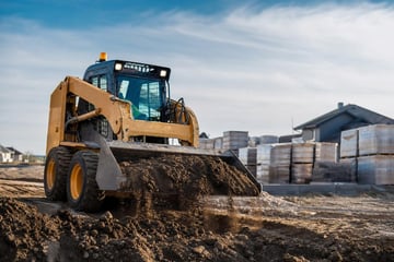 Skid steer loader at a commercial worksite, illustrating skid steers financing for small business: what to expect
