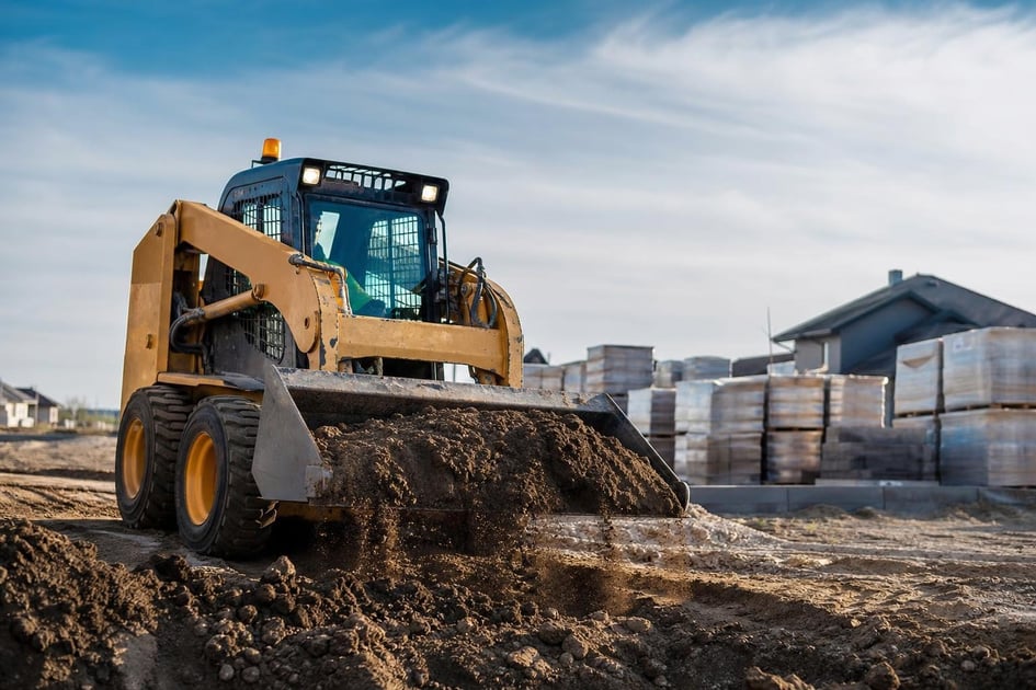 Skid steer loader at a commercial worksite, illustrating skid steers financing for small business: what to expect